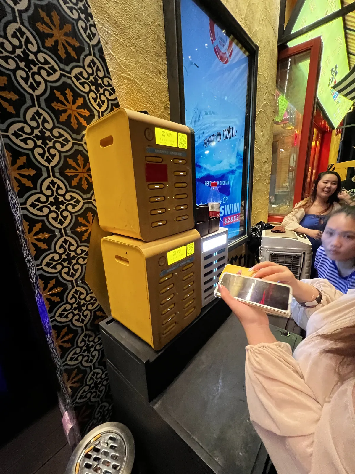 A customer scanning a rental station on a bar top at night